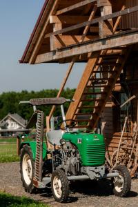 einem grünen Traktor vor einem Gebäude in der Unterkunft Tourist Farm Firbas in Cerkvenjak