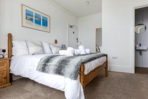 a bedroom with a large bed with a blanket on it at Ocean House in St Ives