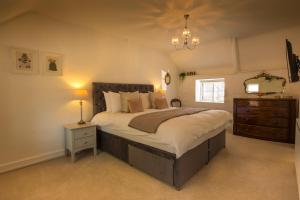 a bedroom with a large bed and a chandelier at The Cott Inn in Totnes