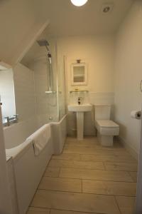 La salle de bains est pourvue d'un lavabo, d'une baignoire et de toilettes. dans l'établissement The Cott Inn, à Totnes
