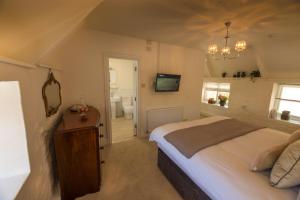 1 dormitorio con 1 cama grande y baño en The Cott Inn en Totnes