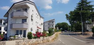 a white building on the side of a street at Apartment Milka 1 in Njivice
