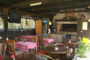 a restaurant with tables and chairs and a television at House Maka in Rudanovac