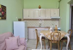 a kitchen with a table with chairs and a refrigerator at Theodora in Patitiri