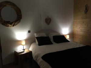 a bedroom with a bed with two lamps and a mirror at La Perle Des Alpes C2 in Villard-sur-Doron