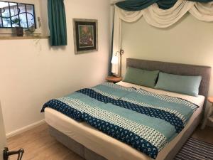 a bedroom with a bed with a blue and white comforter at Ferienwohnung am Hörnle in Bad Kohlgrub