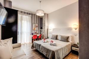 Santamaggiore في روما: غرفة نوم بسرير وطاولة مع كراسي حمراء