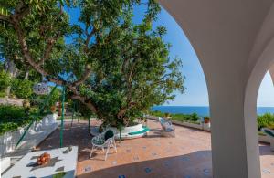 uma vista para um pátio com uma árvore e para o oceano em Il Carrubo Capri em Anacapri