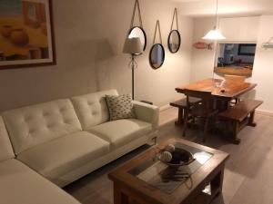 un soggiorno con divano bianco e tavolo di Condominio San Alfonso del Mar ad Algarrobo