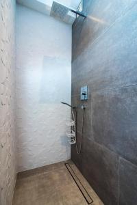 a bathroom with a shower with a wall at Apartments Villa Castello in Kaštela