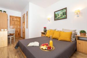 a bedroom with a bed with a tray of fruit on it at Arenda in Karwia