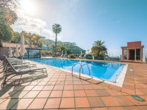 a swimming pool with two lounge chairs next to it at Ocean Gardens in Funchal