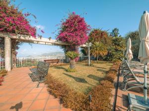 a patio with chairs and pink flowers and a fence at Ocean Gardens in Funchal