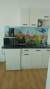 a kitchen with white cabinets and a counter top with flowers at Villa Franko in Prizna