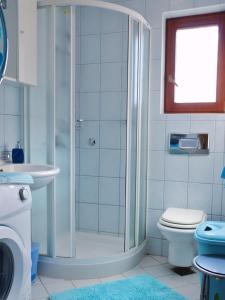 a bathroom with a shower and a toilet and a sink at Apartman I&A in Porat