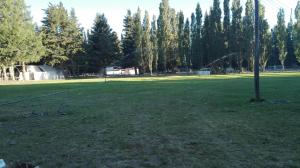 un parque con un poste en medio de un campo en Donde brilla el sol en Dina Huapi