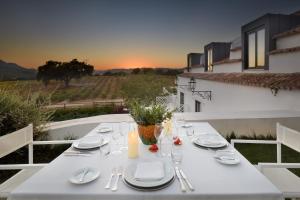 a white table with white plates and utensils on a table at Hotel Casa Palmela - Small Luxury Hotels of The World, Hotel & Villas in Setúbal