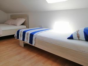 sypialnia z 2 łóżkami i drewnianą podłogą w obiekcie Apartments Venerea w Nin