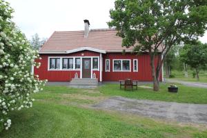uma casa vermelha com uma mesa de piquenique em frente em Villa Taikinajoki em Pertunmaa