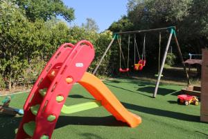 a playground with a slide and a swing set at Villa Argo 2 - Beachfront, Big gardens, Location! in Pefkochori