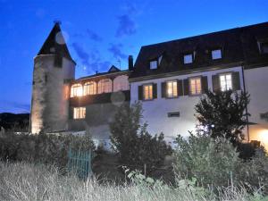 a large building with lights on at night at Les Gîtes de la tour, appartement "le Vignoble" in Saint-Hippolyte