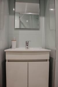 a bathroom with a white sink and a mirror at Apartamento central, moderno e luminoso - Self check in in Coimbra