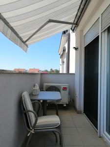 taras ze stołem i krzesłami na balkonie w obiekcie Apartments Venerea w Nin
