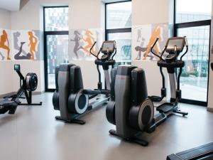 a gym with treadmills and elliptical machines at Q Hotel Plus Kraków in Kraków