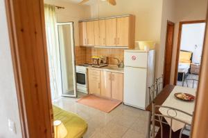 a kitchen with a white refrigerator and a table at Nikos Apartments in Ormos Panagias