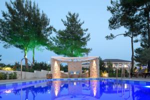 a swimming pool with a gazebo next to a resort at Alexandra Beach Spa Resort in Potos