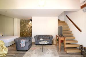 a living room with a couch and a tv and stairs at Alexandra Beach Spa Resort in Potos