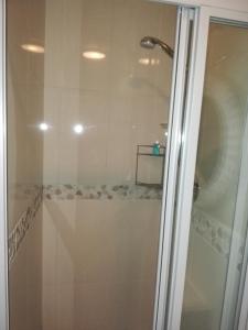 a shower with a glass door in a bathroom at 504 Witsand in Bloubergstrand