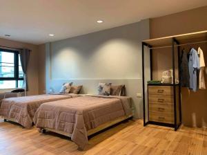 a bedroom with two beds and a dresser at ICON HOSTEL in Bangkok