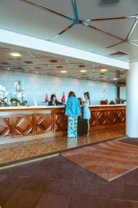 two people standing at a bar with their luggage at Ocean Gardens in Funchal
