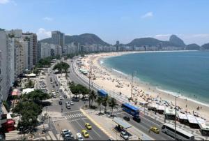 a beach with a lot of people and the ocean at Atlântica 1002 in Rio de Janeiro