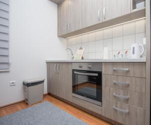uma cozinha com armários de madeira e um forno com placa de fogão em Apartman Emir 1 em Sarajevo