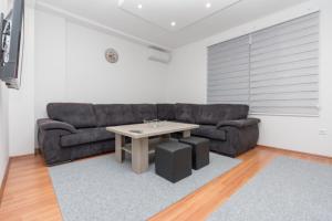 uma sala de estar com um sofá e uma mesa em Apartman Emir 1 em Sarajevo