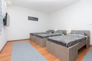 two beds in a room with wooden floors at Apartman Emir 1 in Sarajevo