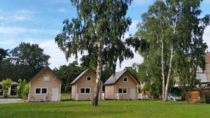 een groep huizen in een tuin met bomen bij Te Domki in Łukęcin