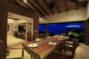 a dining room with a large wooden table and chairs at Villa Numu in Mal País
