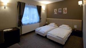 ein Hotelzimmer mit 2 Betten und einem Fenster in der Unterkunft Varga-ház panzió in Budaörs