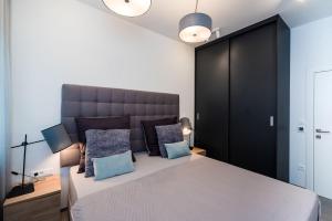 1 dormitorio con 1 cama grande con almohadas azules en Apartments Villa Castello, en Kaštela