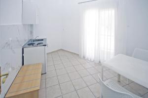 a kitchen with a stove and a tiled floor at Aqua Marine 2 in Neos Marmaras