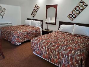 Habitación de hotel con 2 camas y espejo en Sonoma Lodge, en Bend