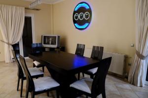 Un comedor con una mesa y sillas negras. en VILLA KONSTANTINOS, en Aegina Town