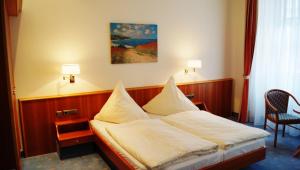 a hotel room with a bed with pillows on it at Hotel Goldener Löwe in Waldheim