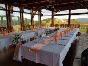 a group of tables with white table cloths and orange vases at Вили Чала in Chala