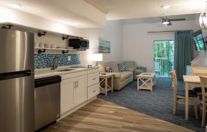 a kitchen and living room with a couch and a table at Palmera Inn and Suites in Hilton Head Island