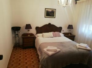 a bedroom with a bed with two towels on it at O Parque in Arzúa