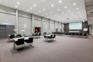 a conference room with tables and chairs and a projection screen at Thon Hotel Høyers in Skien